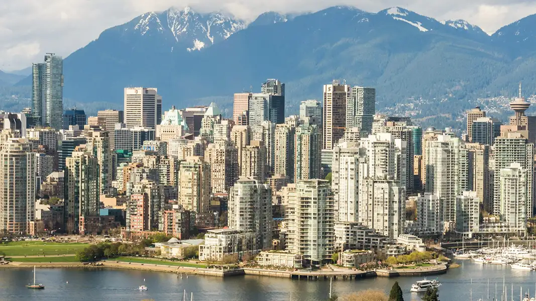 Photo of city buildings infront of a rocky mountain