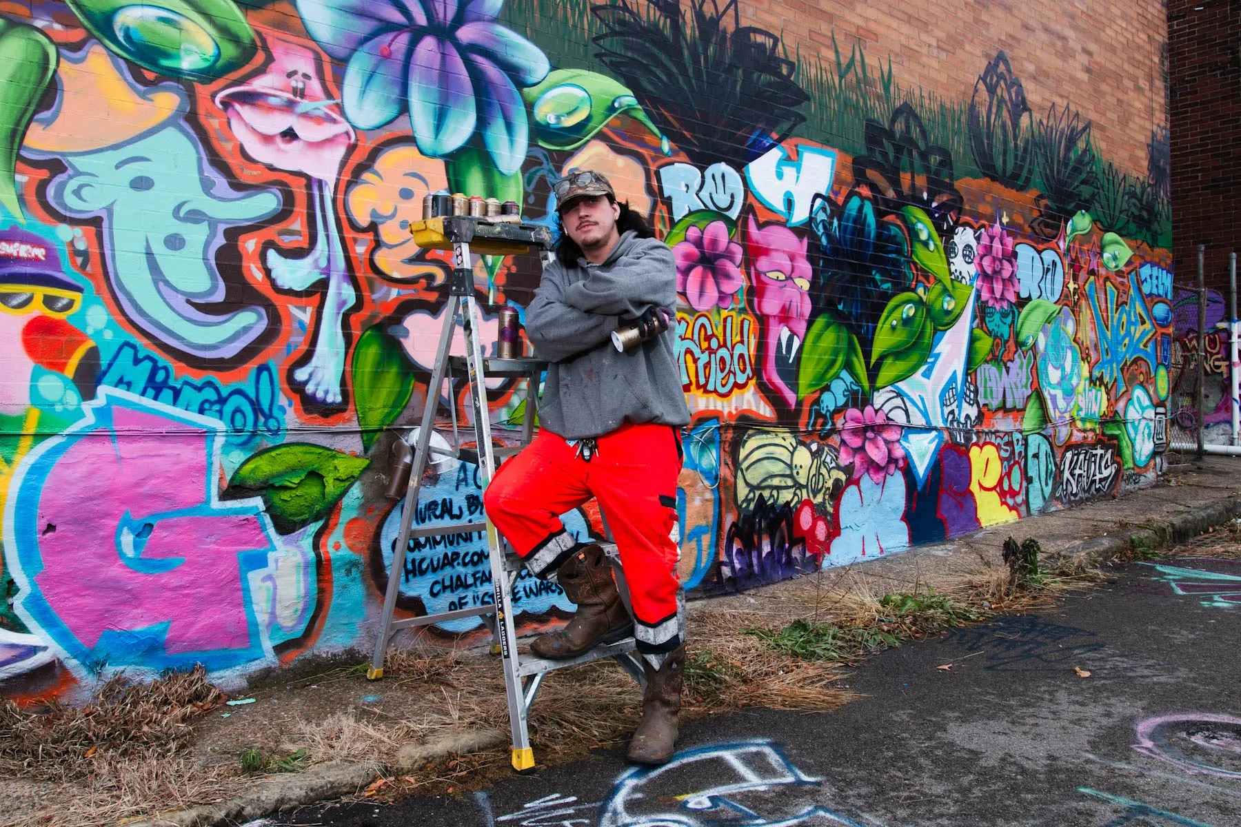 Pittsburgh graffiti artist standing in front of hiw artwork