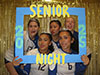 Hadasyah, Maria, Emily, Faith, and Abby smiling on their volleybal senior night with a nice poster and gold background.