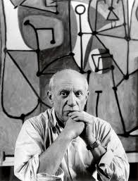 Black and white image of Pablo Picasso serious face art behind him.