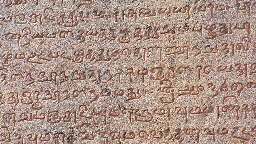 Ancient Tamil writing on a stone tablet.