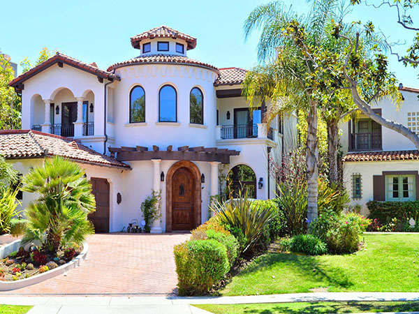 A nice mediterranean house with limestone walls and a winding driveway.